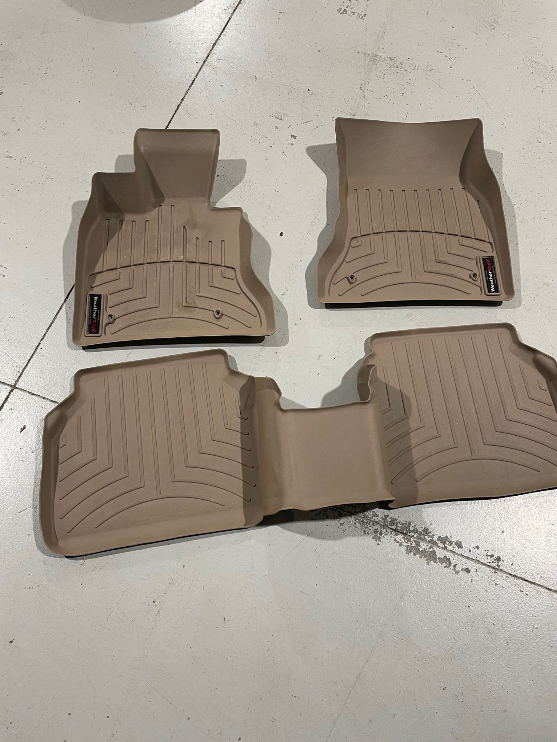 a set of tan floor mats are sitting on a white floor