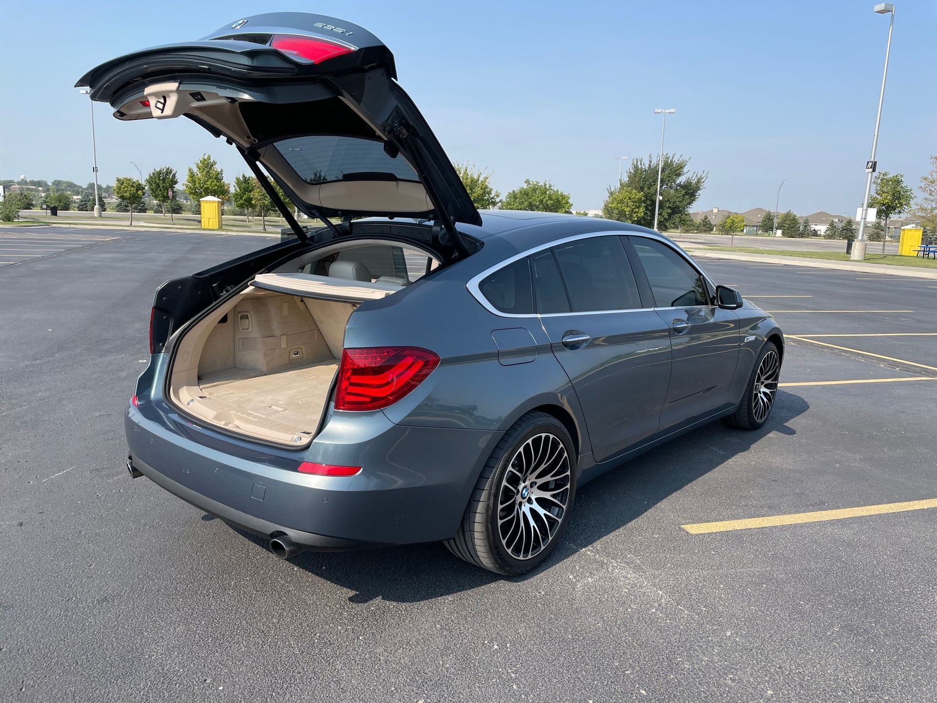 a car with its trunk open is parked in a parking lot