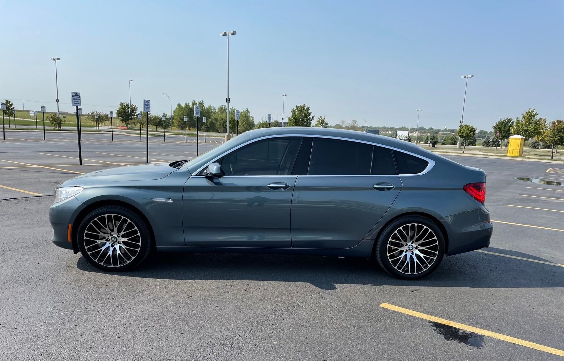 a grey bmw is parked in a parking lot