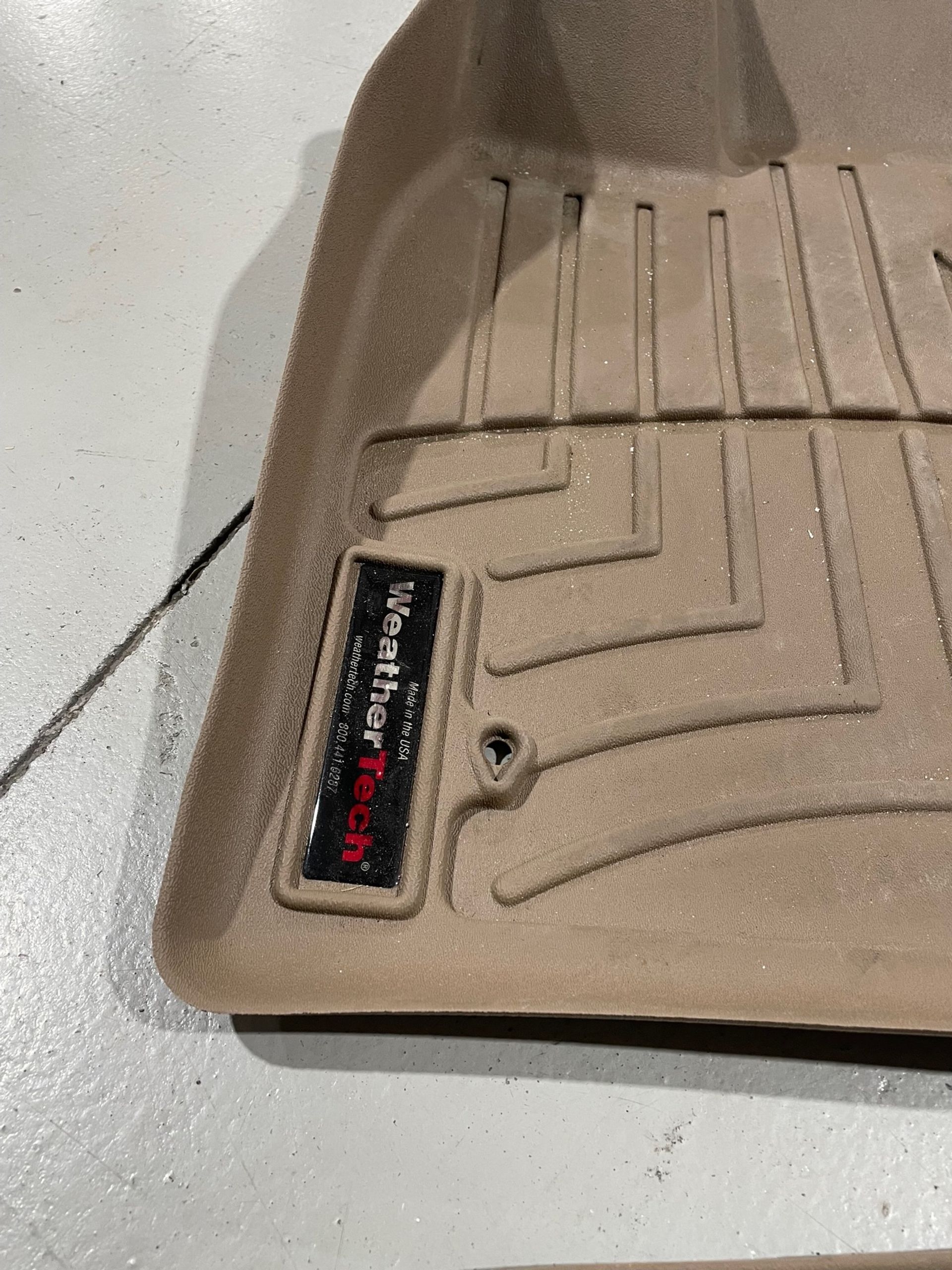 a tan floor mat is sitting on a white surface