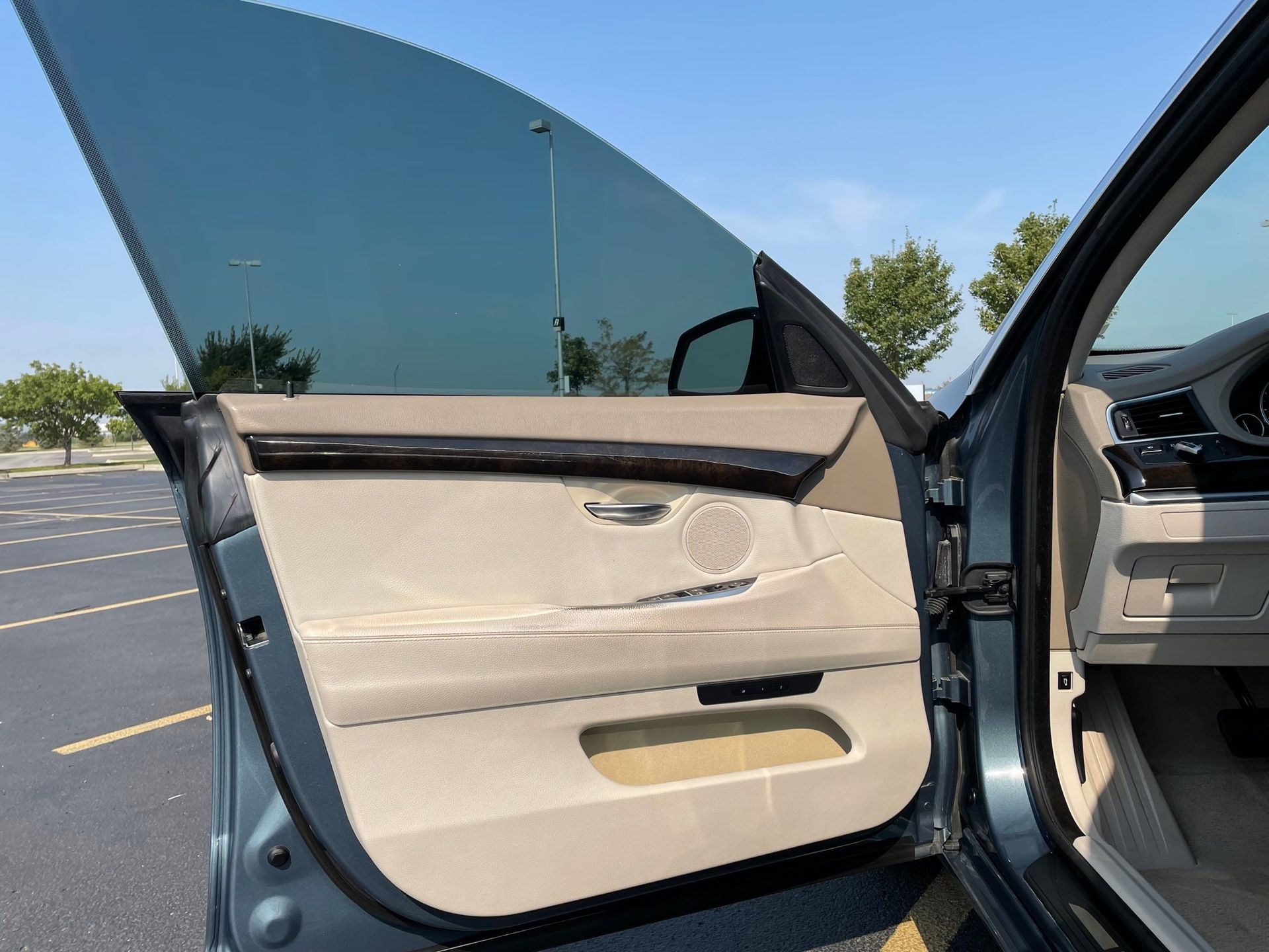 a car with the door open is parked in a parking lot