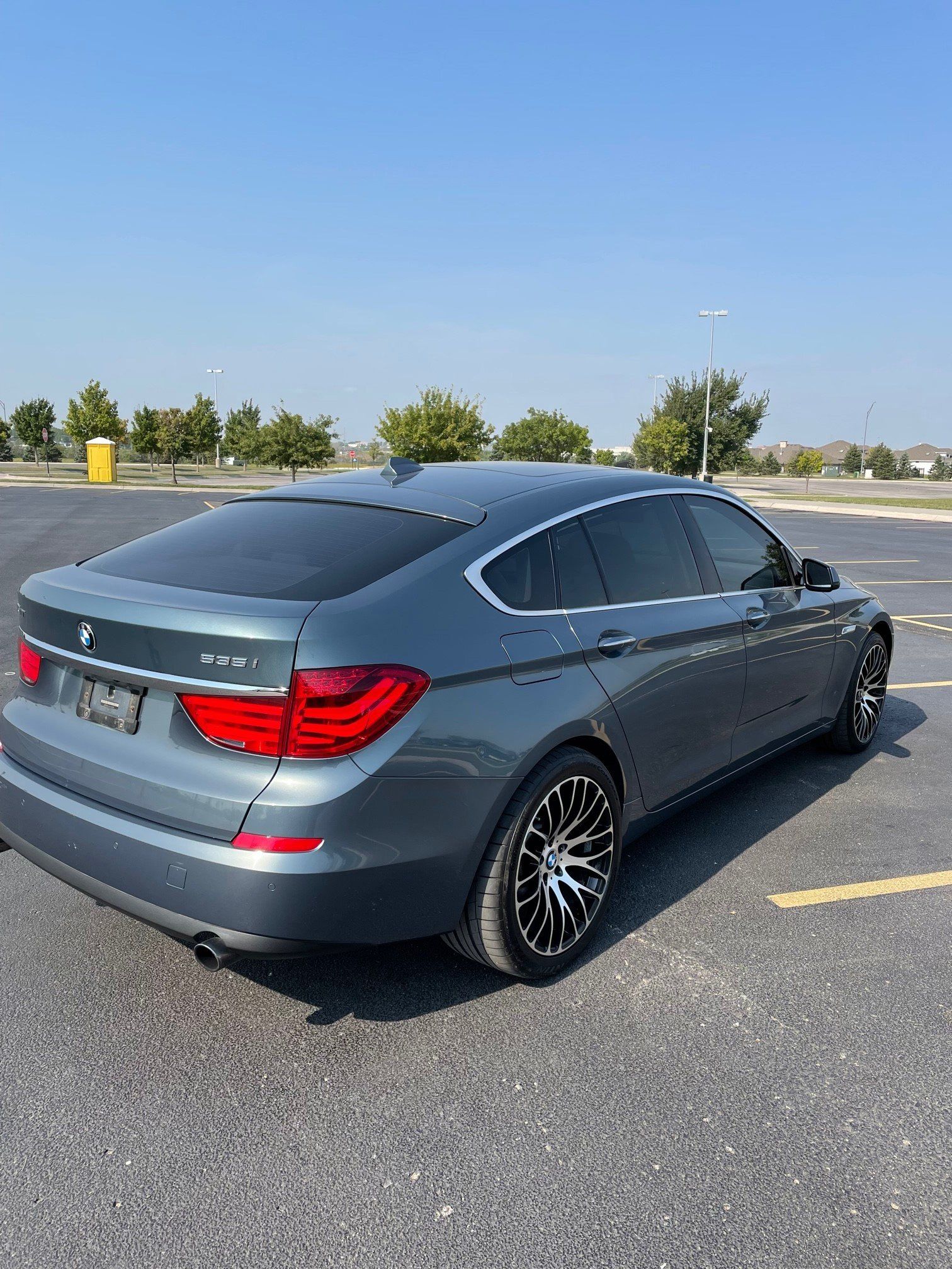 a bmw 5 series is parked in a parking lot on a sunny day
