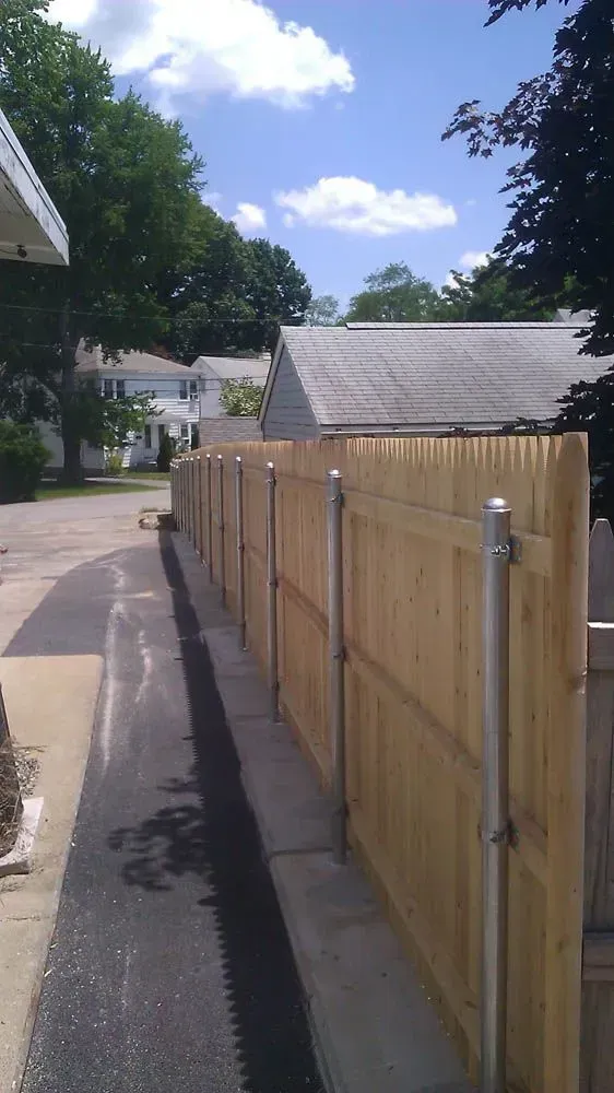 Wooden fence alongside an alleyway on a sunny day.