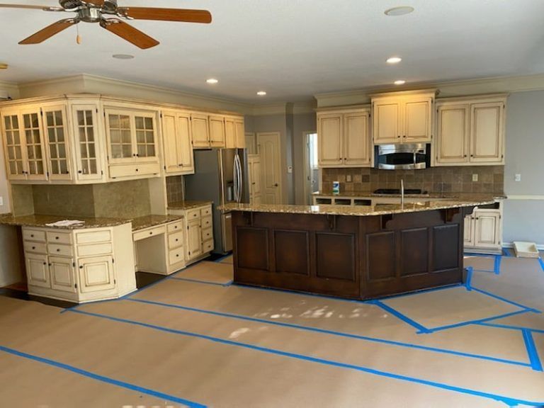 A kitchen with white cabinets and a large island
