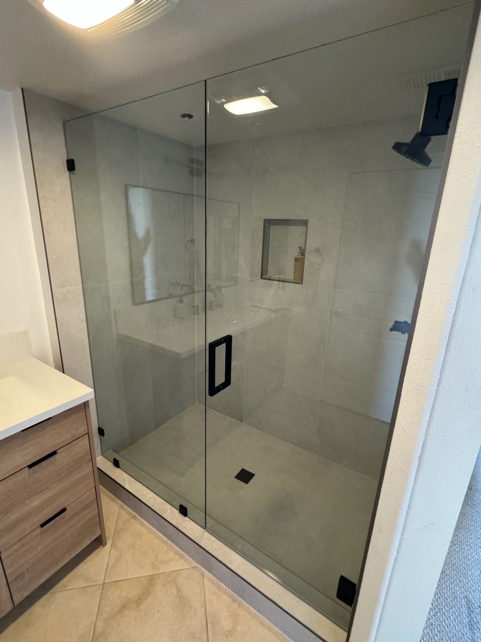 A bathroom with a walk in shower and a sink.