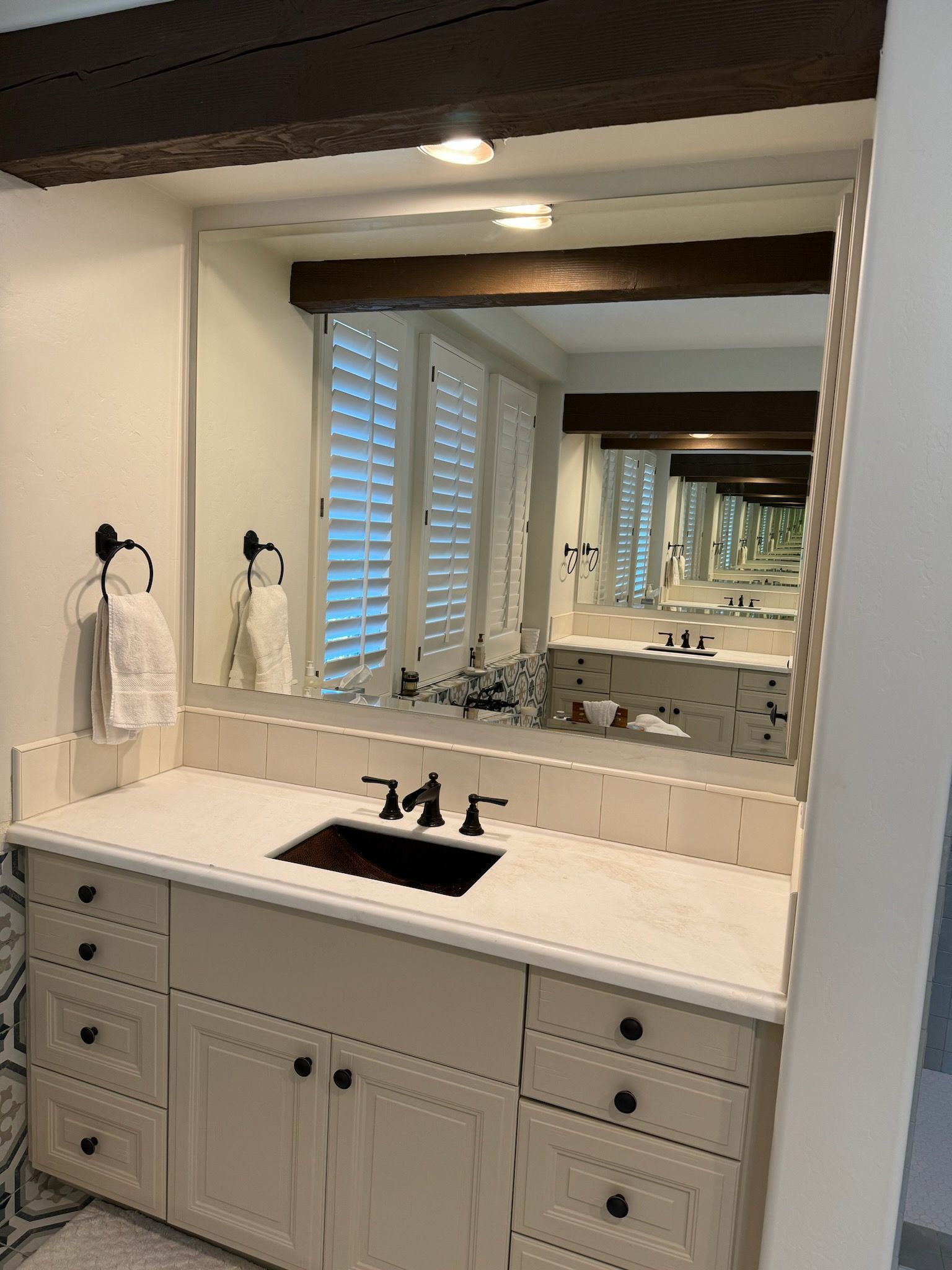 A bathroom with two sinks and a large mirror.