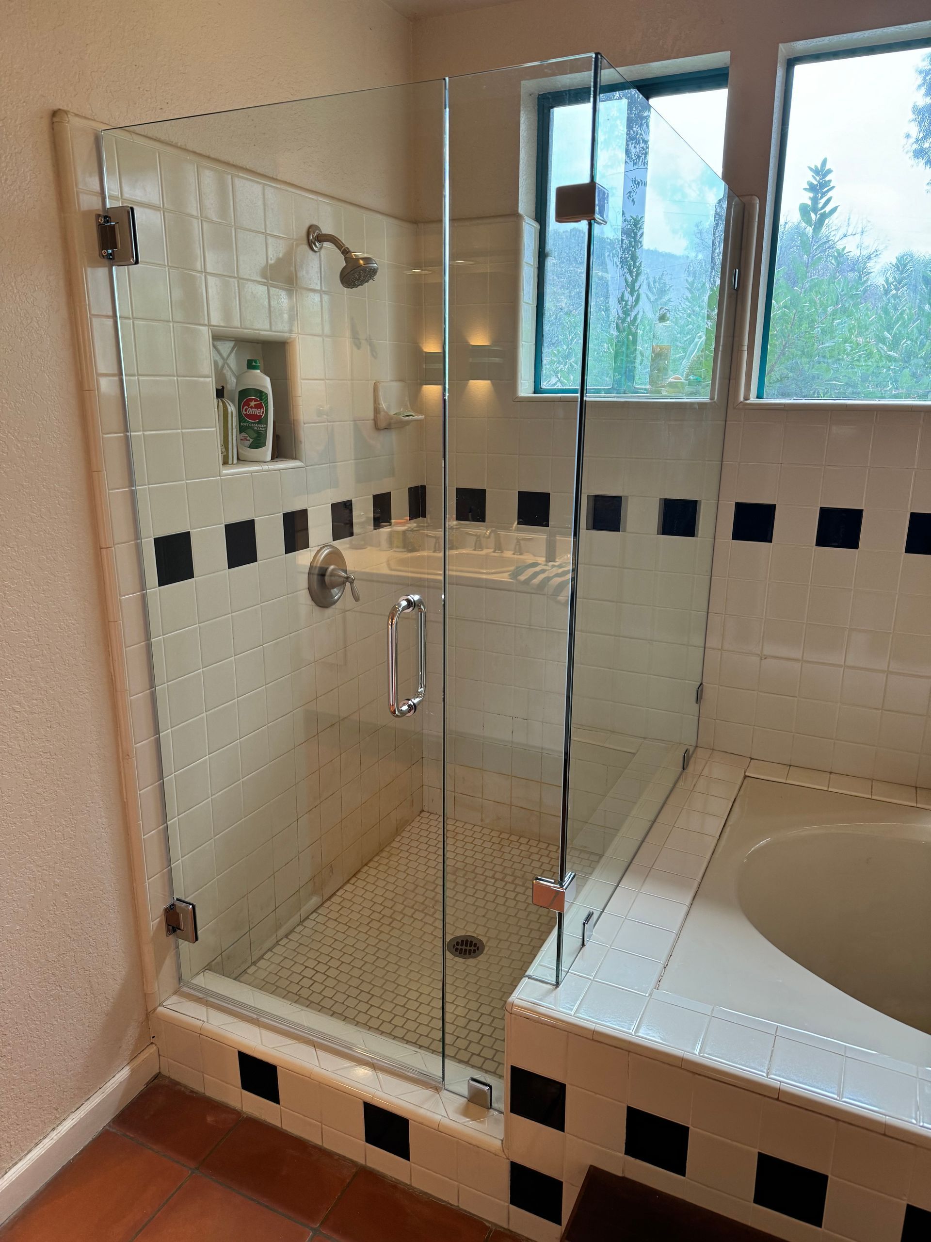 A bathroom with a tub and a shower with a glass door