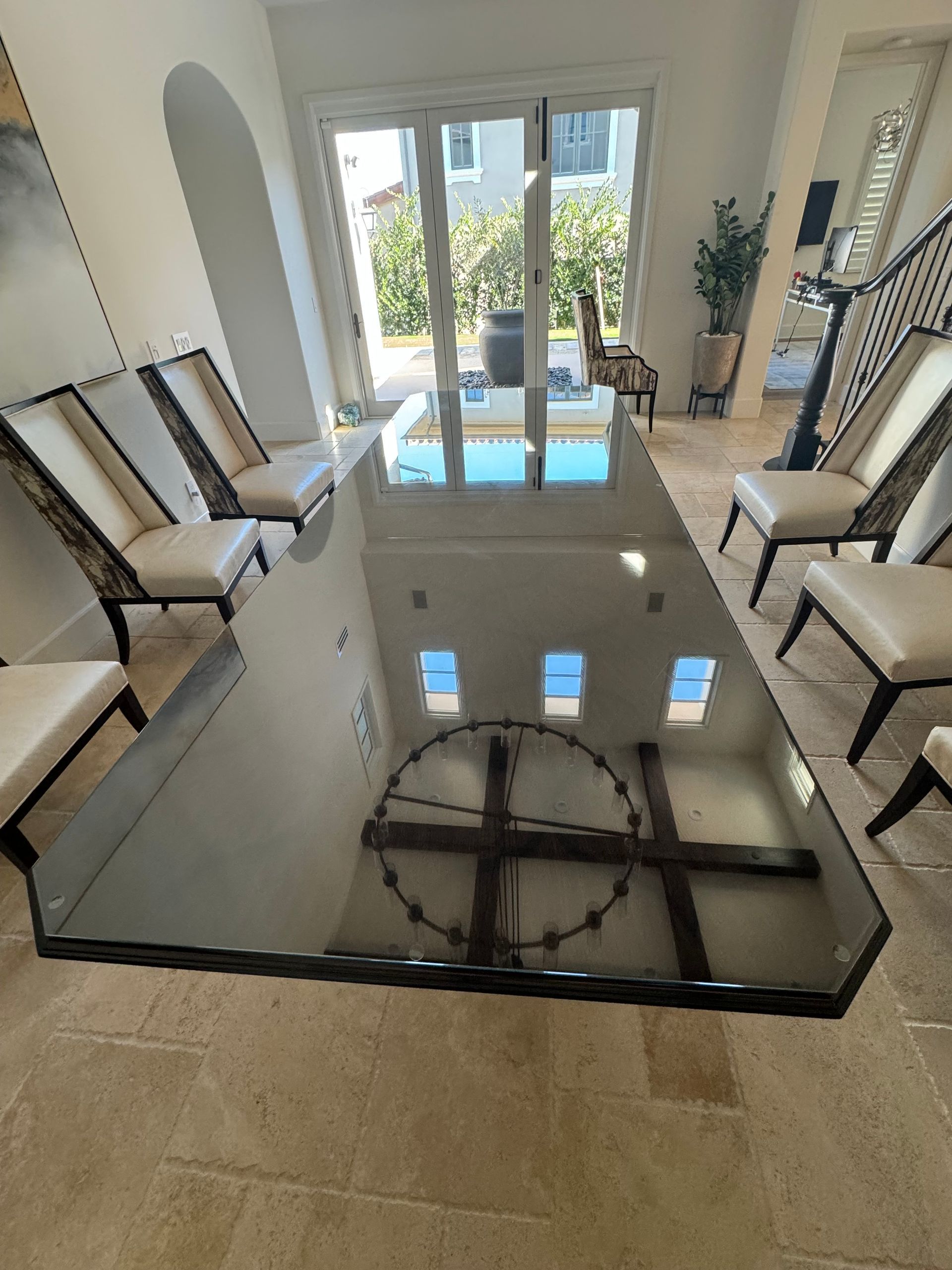 A dining room with a large glass table and chairs.