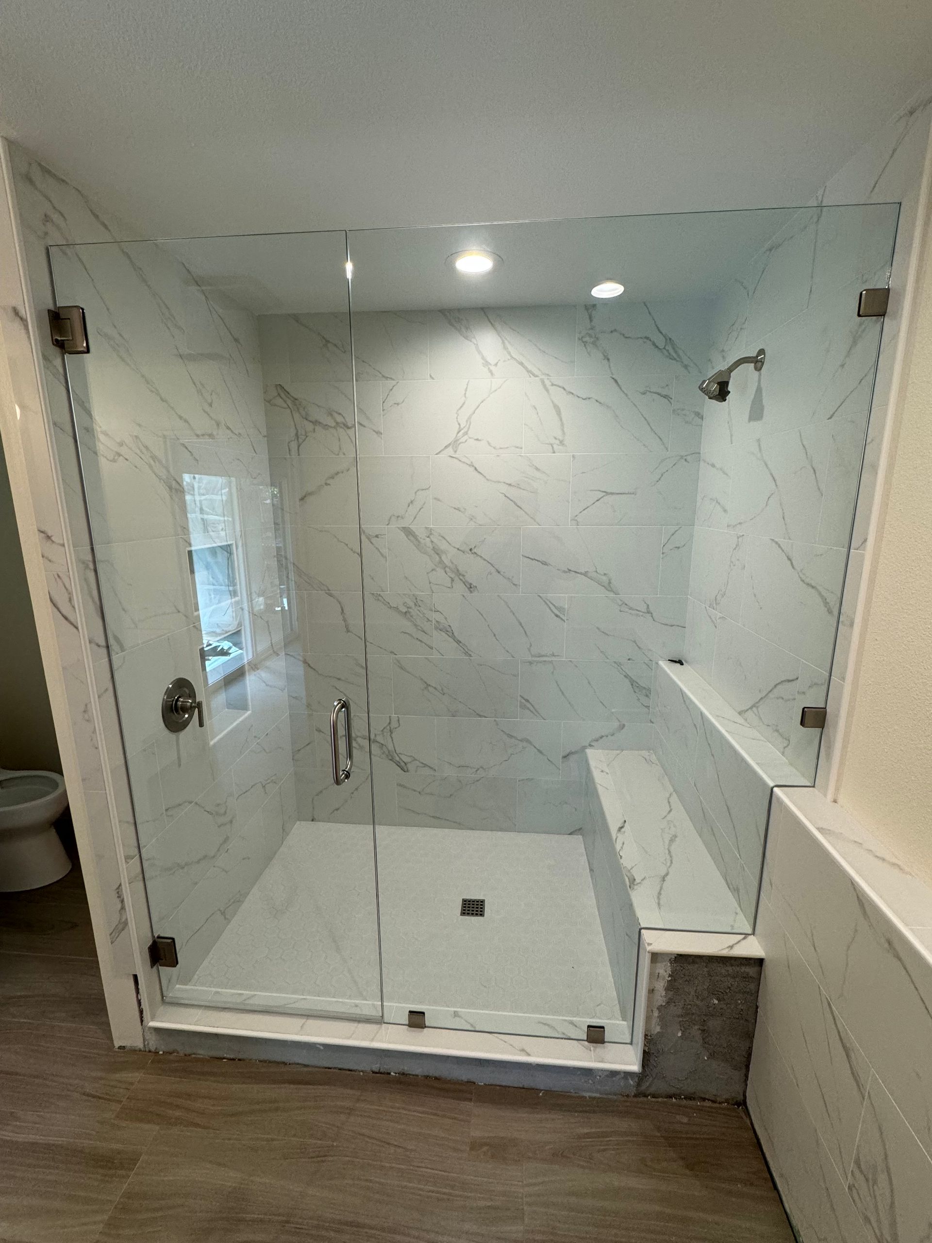 A bathroom with a walk in shower and a toilet.