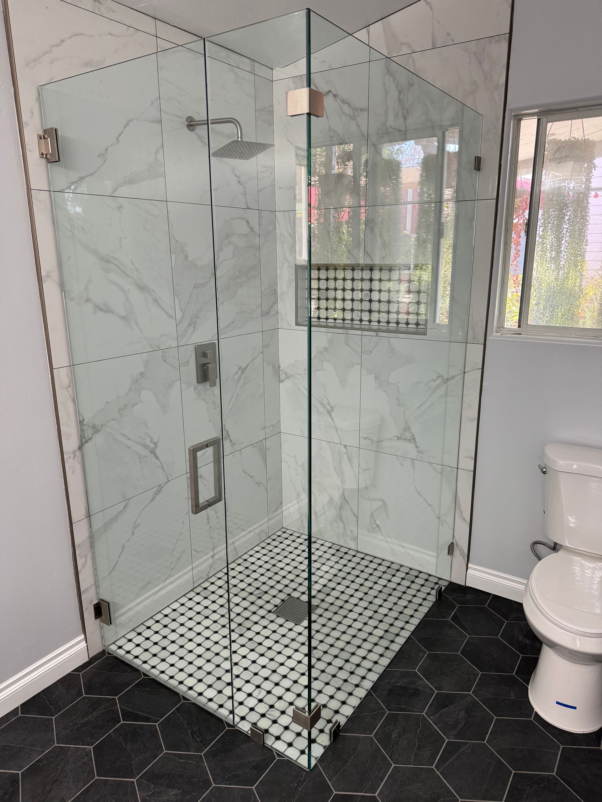 A bathroom with a walk in shower and a toilet.