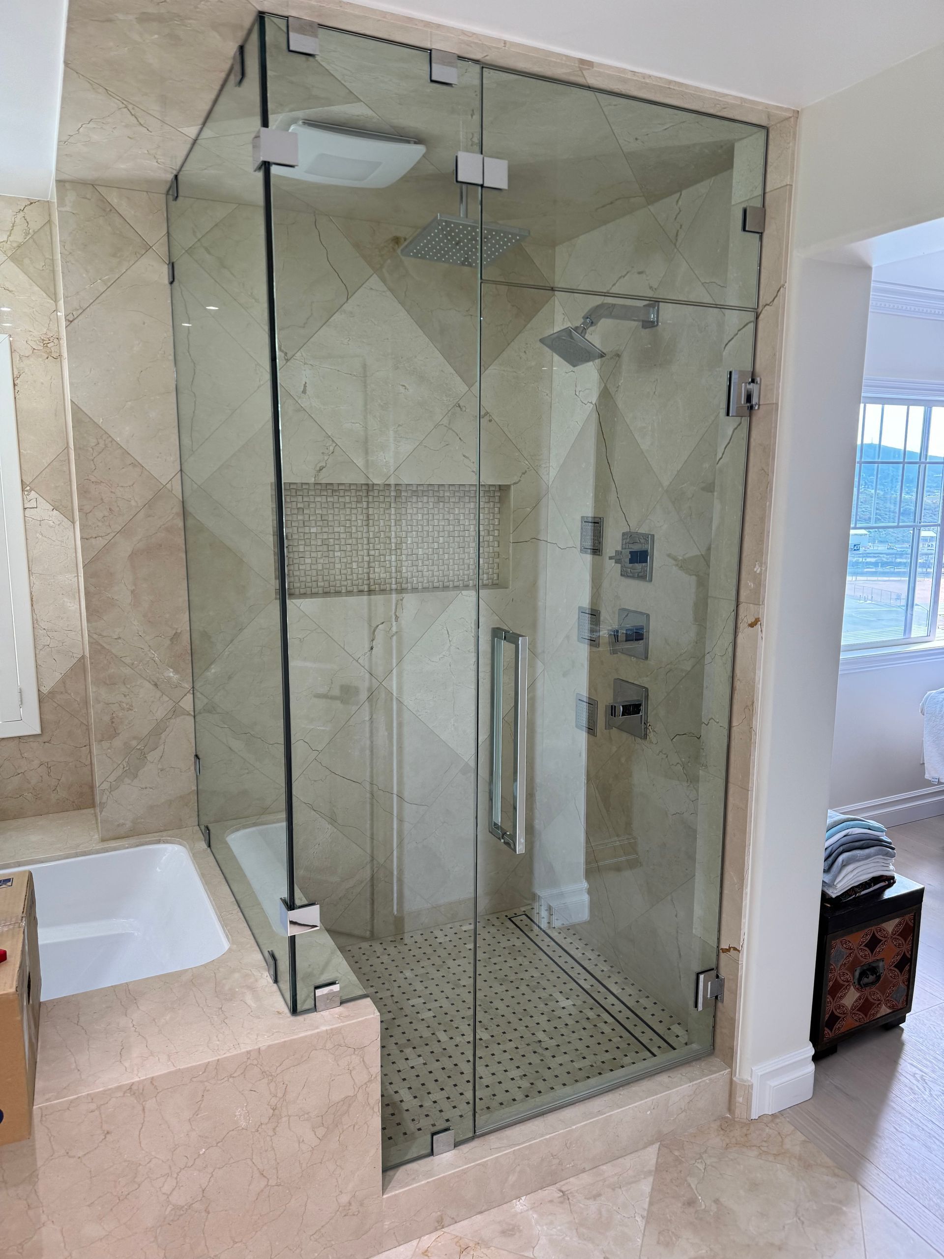 A bathroom with a glass shower door and a bathtub
