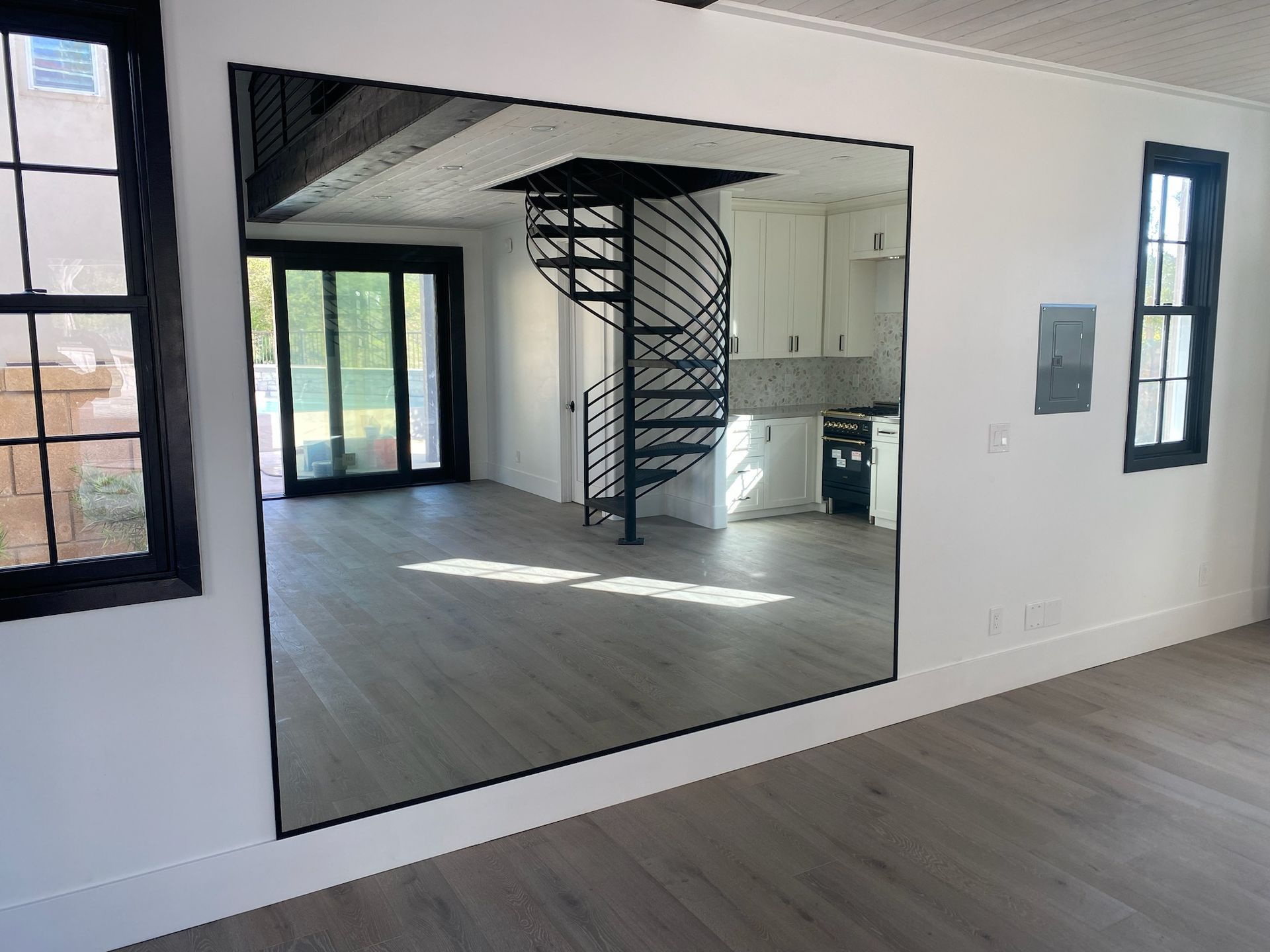 A large mirror is hanging on a wall in a living room.