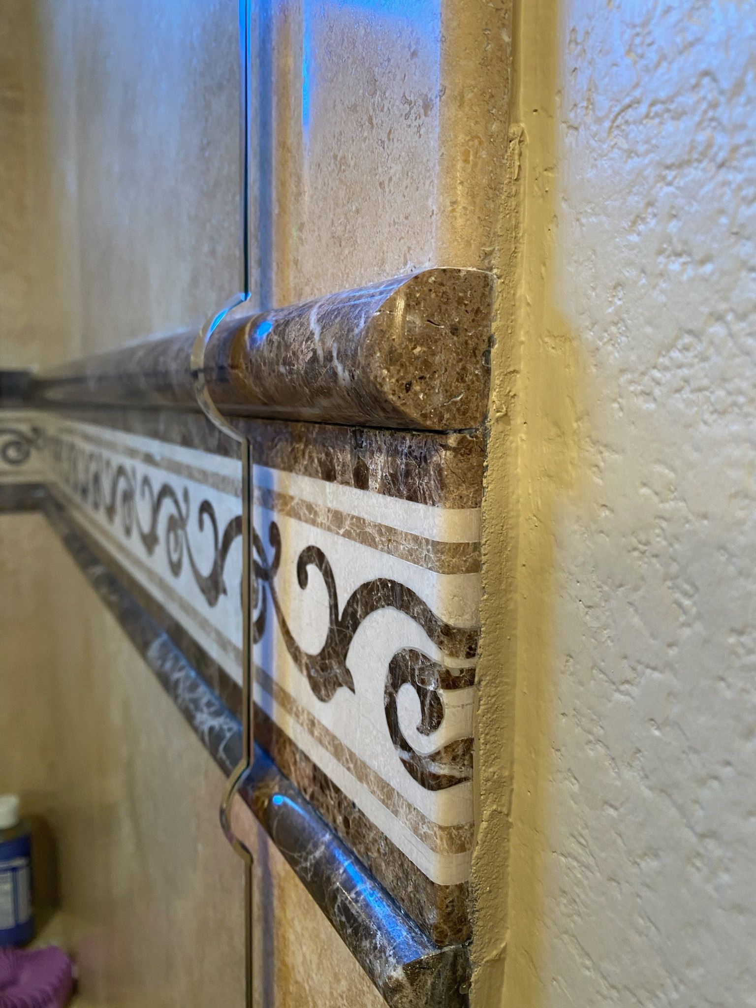 A close up of a marble molding on a wall in a bathroom.