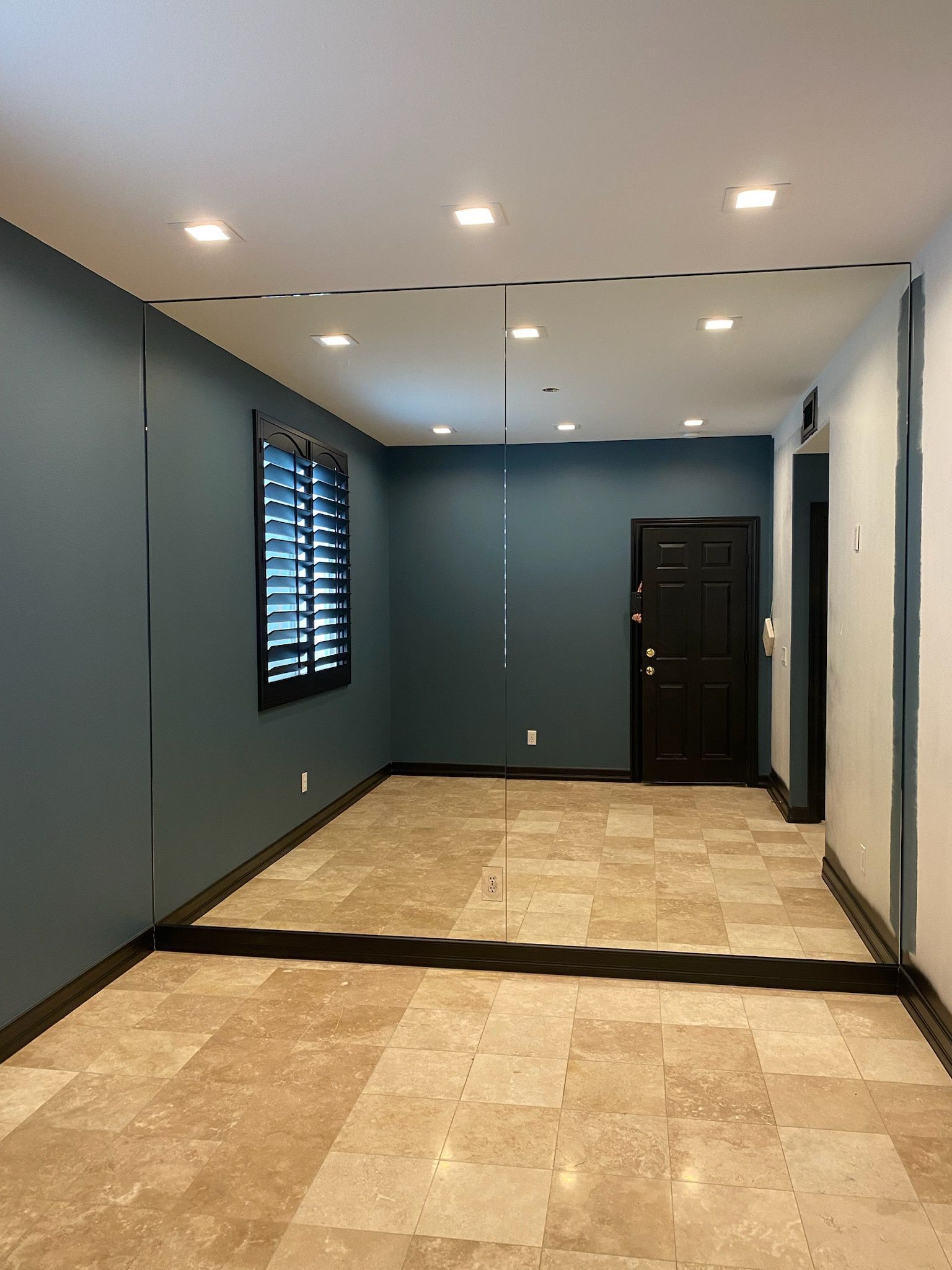An empty room with blue walls and a tiled floor