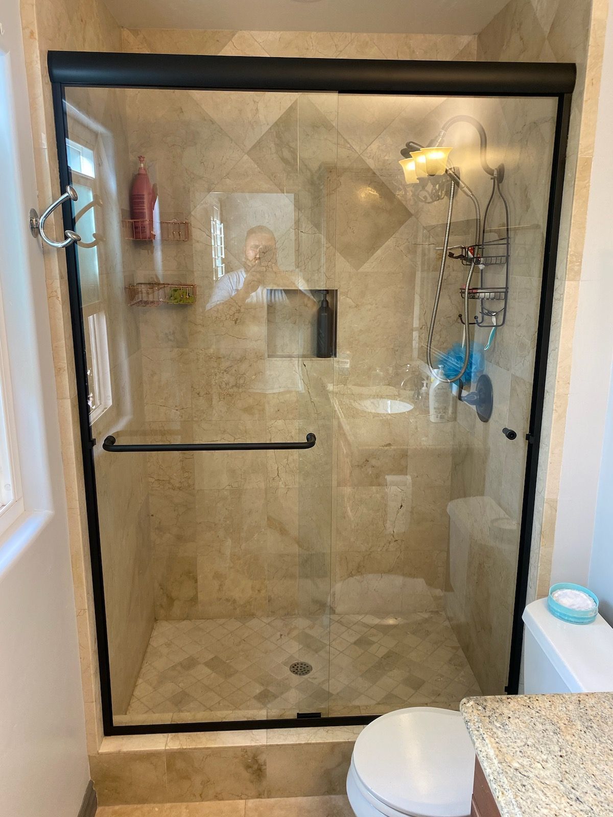 A bathroom with a sliding glass shower door and a toilet.