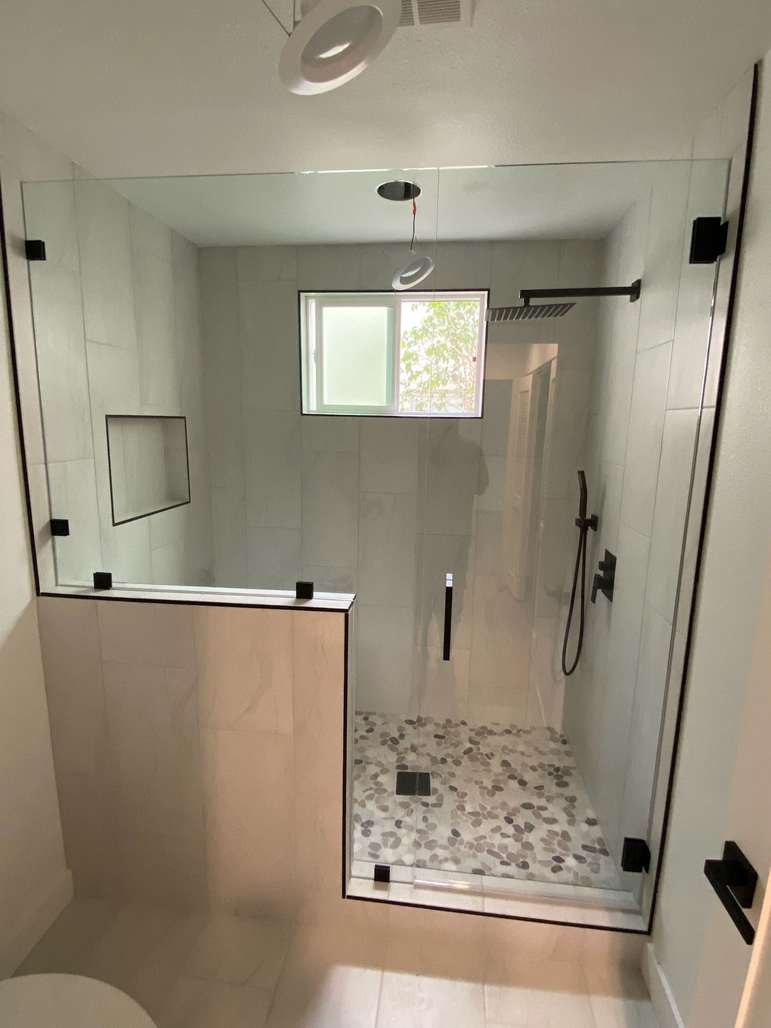 A bathroom with a walk in shower and a toilet.