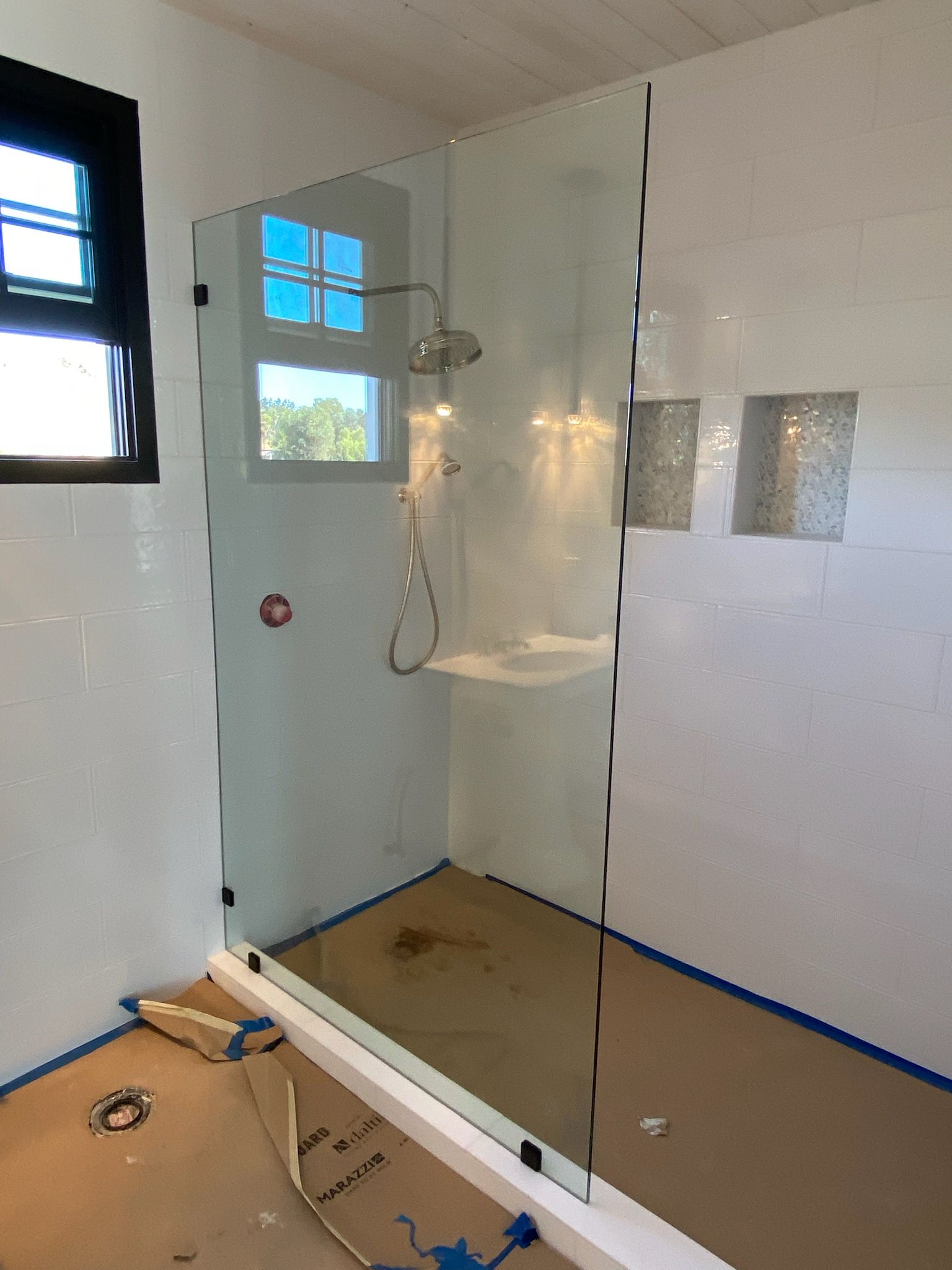 A bathroom with a walk in shower and a sink.