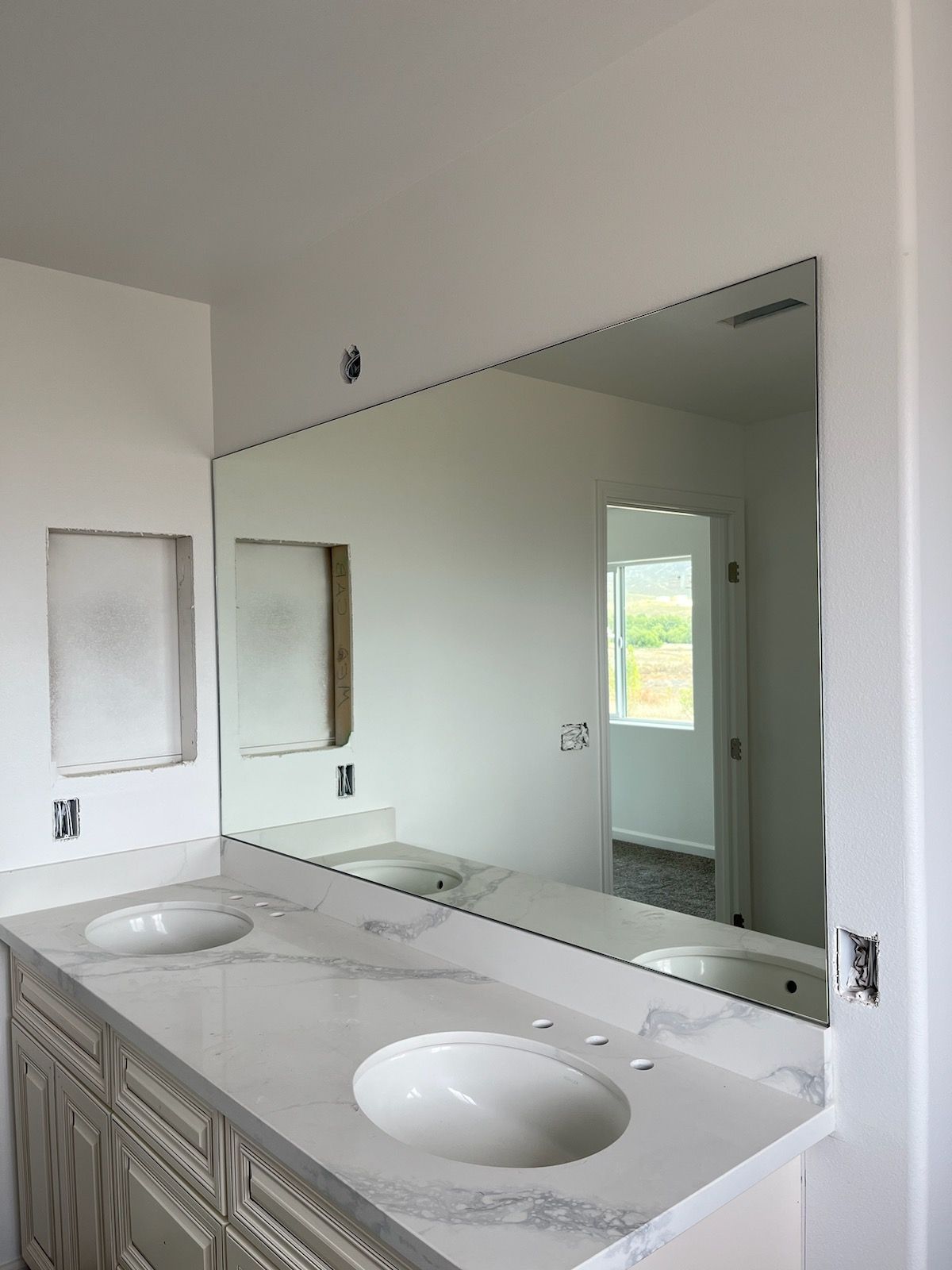 A bathroom with two sinks and a large mirror.