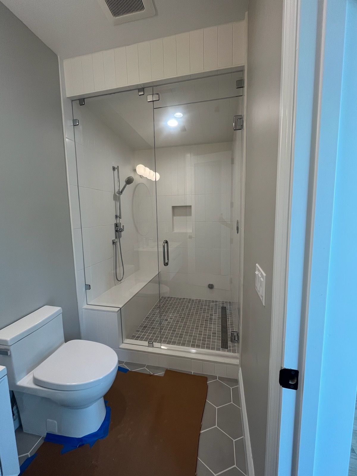 A bathroom with a toilet , shower and bathtub.