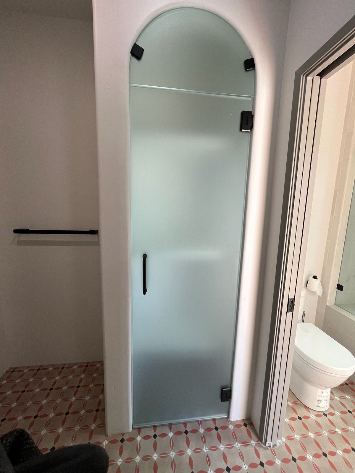 A bathroom with a toilet and a glass shower door.