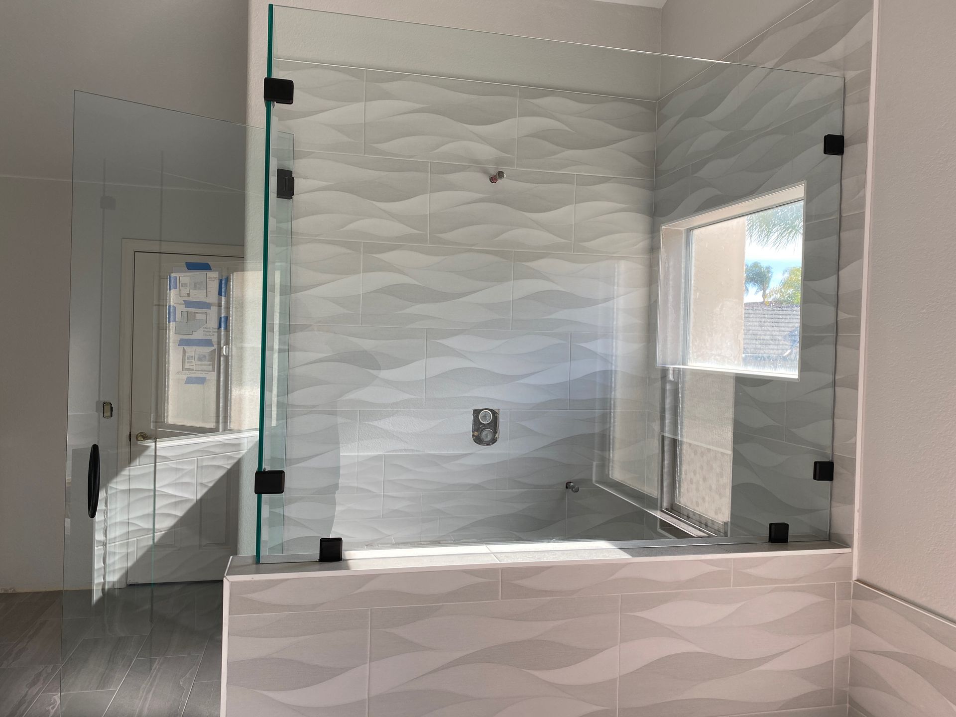 A bathroom with a bathtub and a glass shower door.