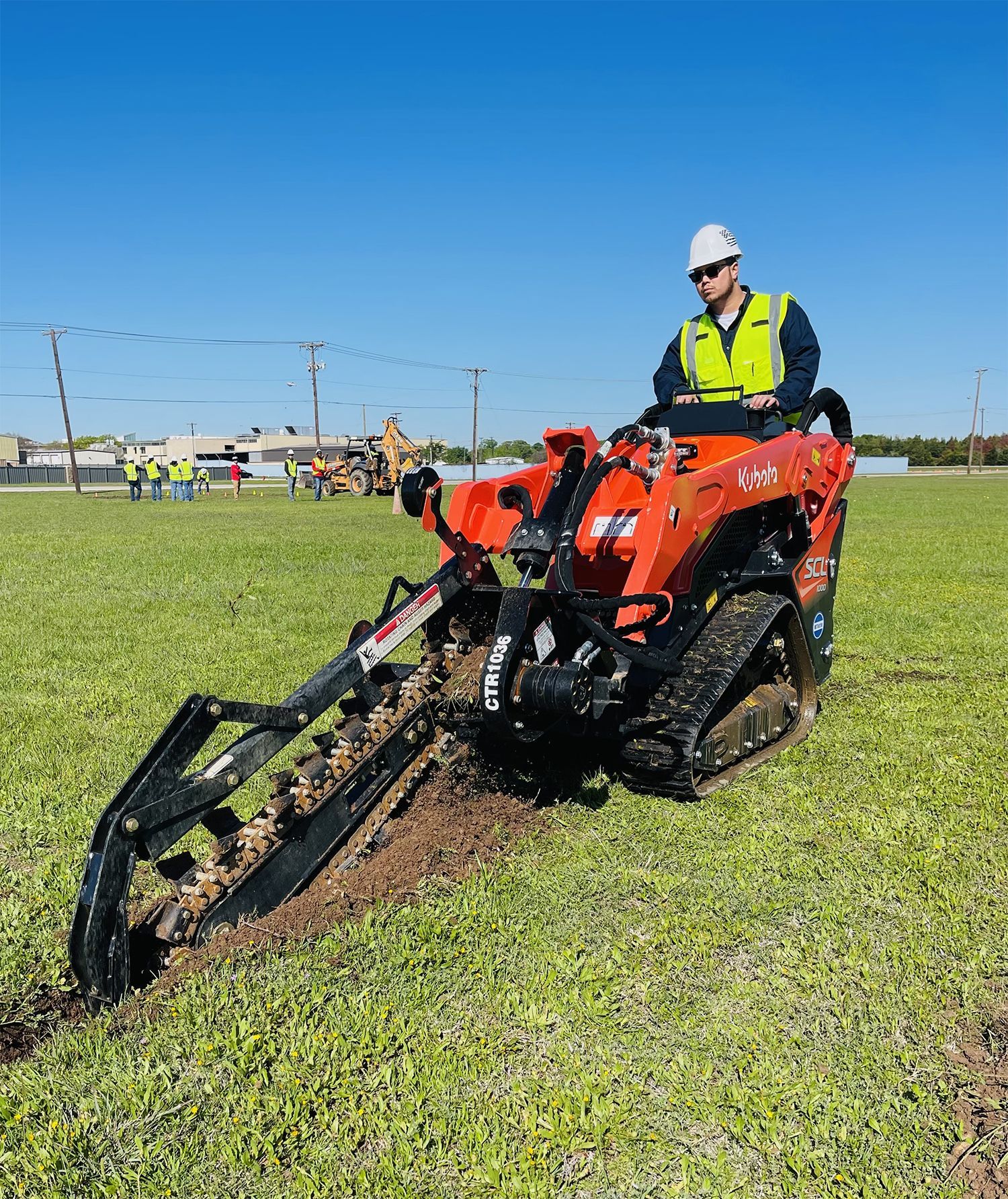 A man is driving a tractor through a grassy field.