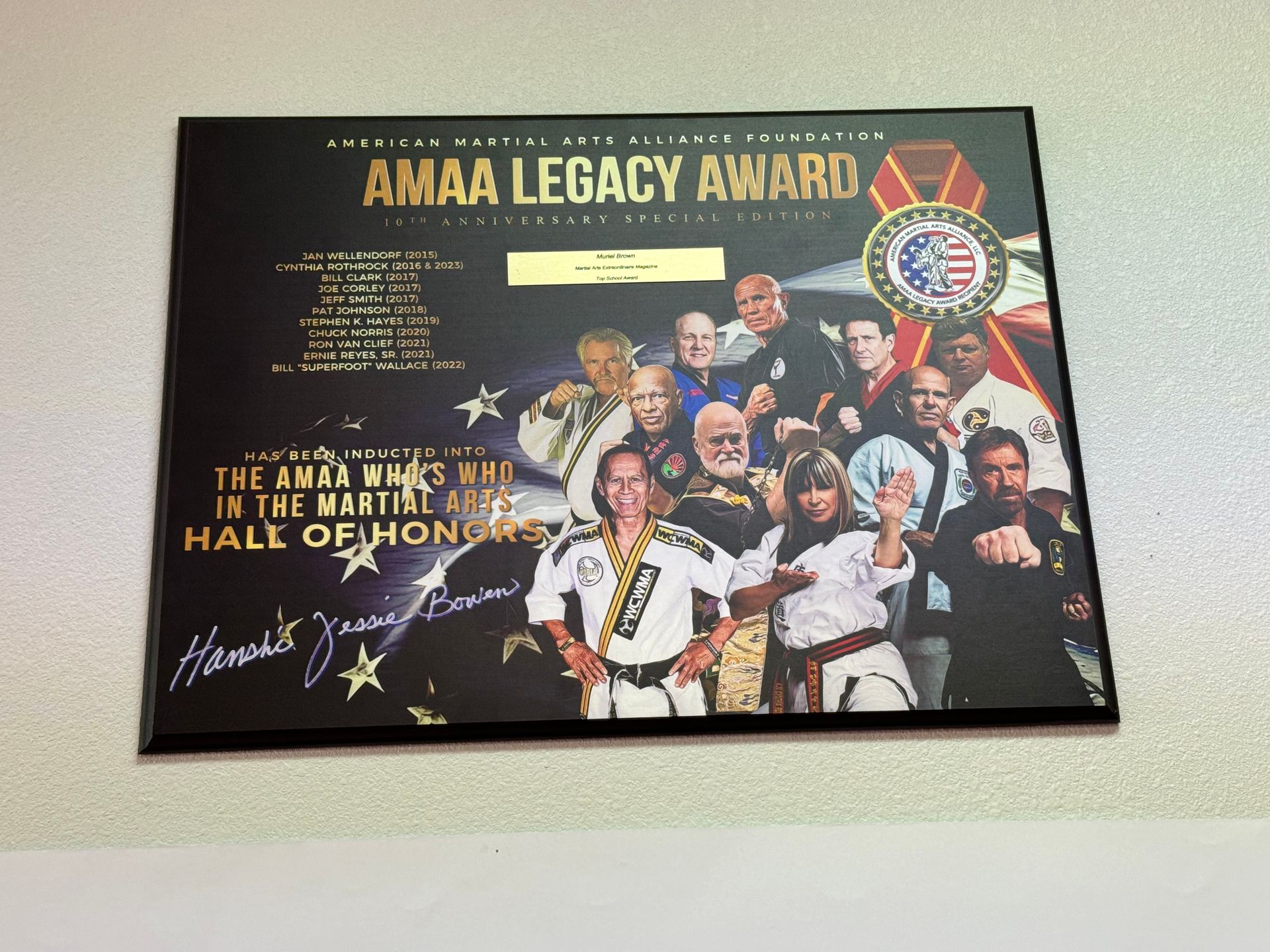 AMA Legacy Award plaque with a group photo, gold text, and a signature on a black background