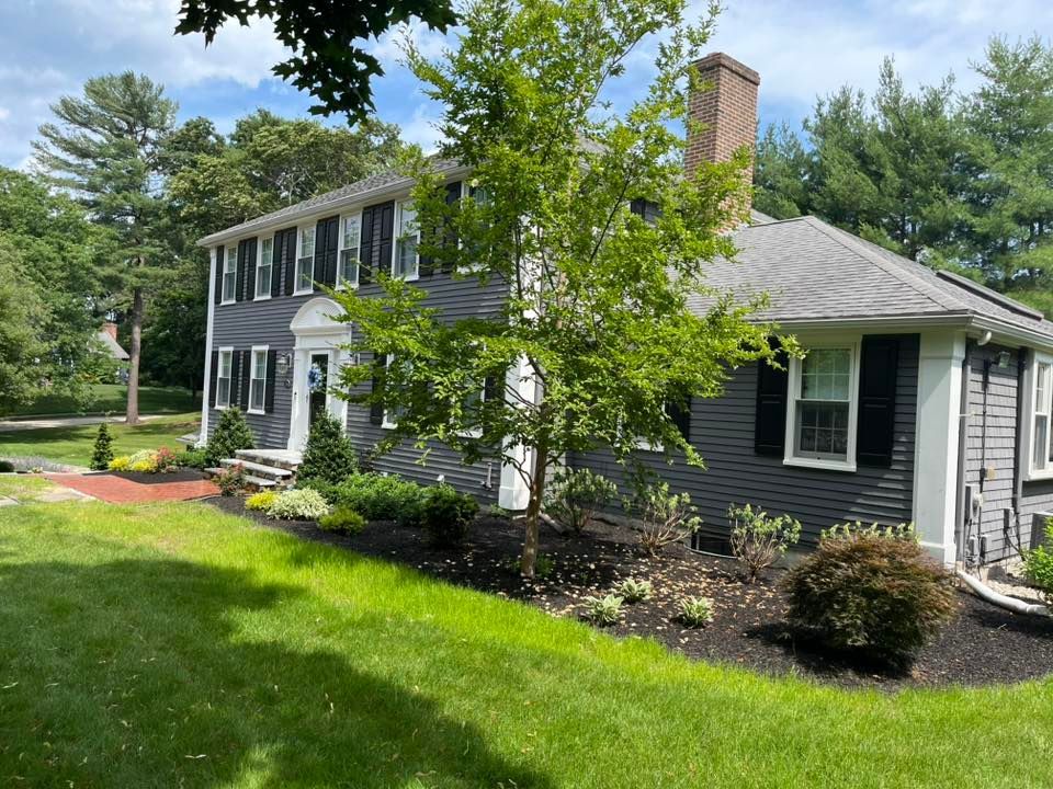 A large house with a large lawn in front of it surrounded by trees.