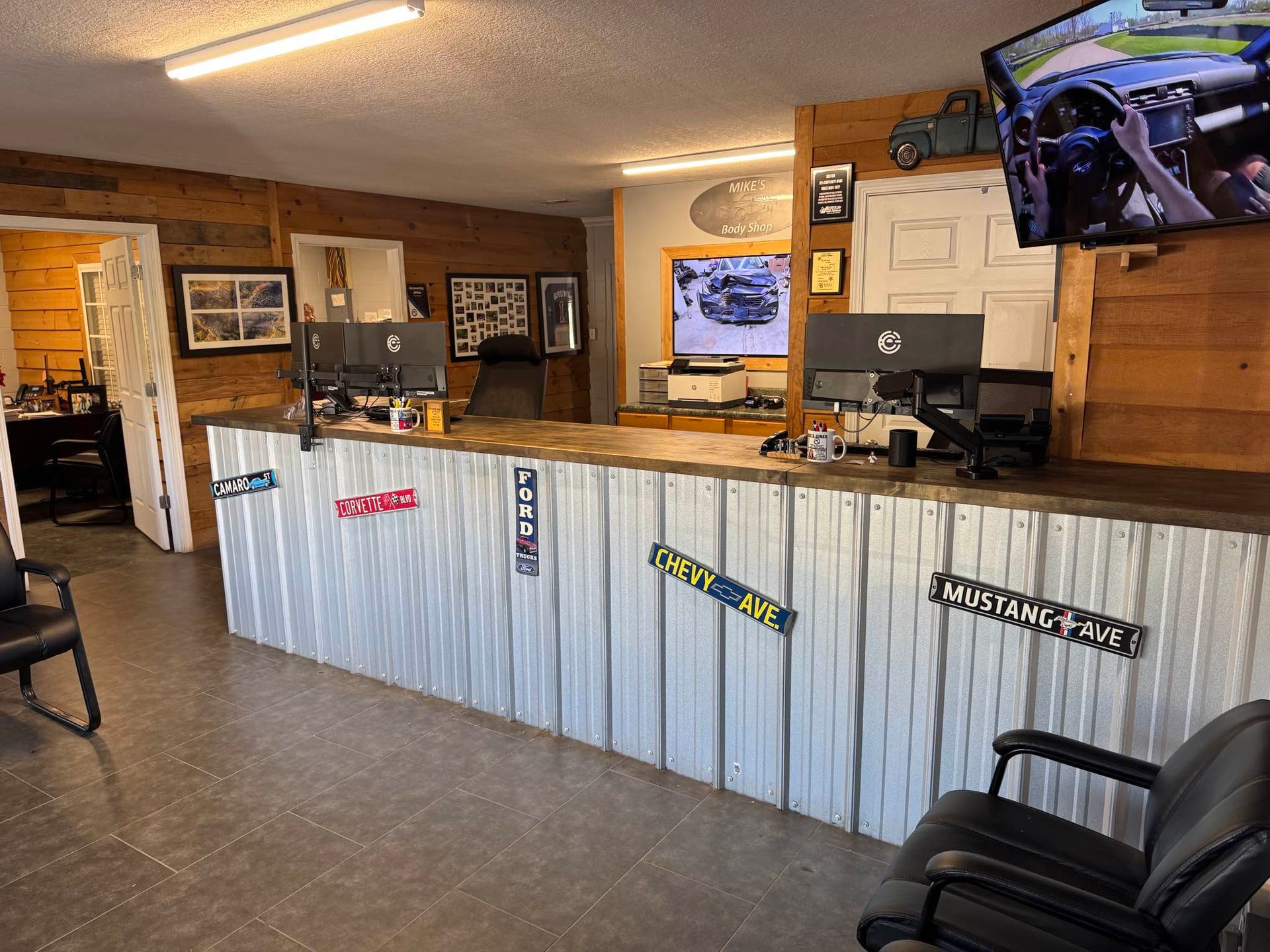 A reception desk with a corrugated metal front decorated with license plates in a rustic-style room.