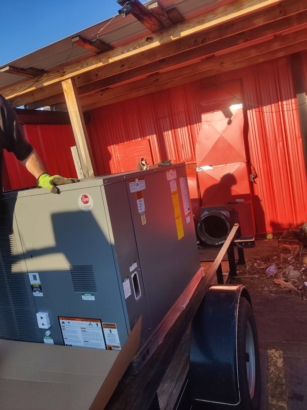 A man is carrying a large box on a trailer.