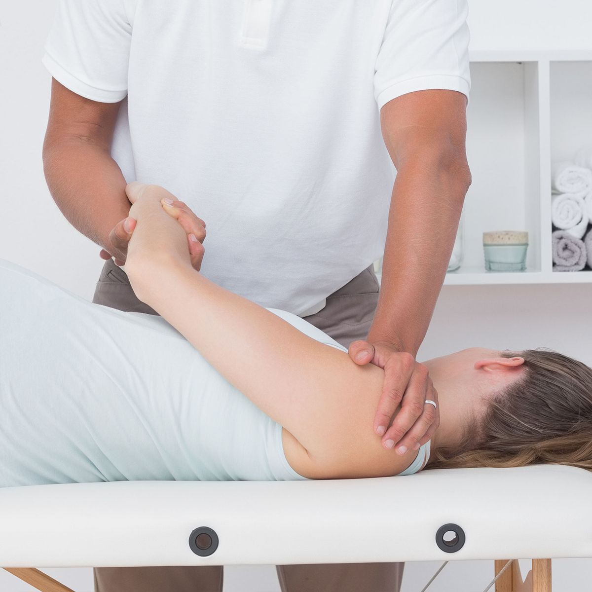 A man is giving a woman a massage on a table