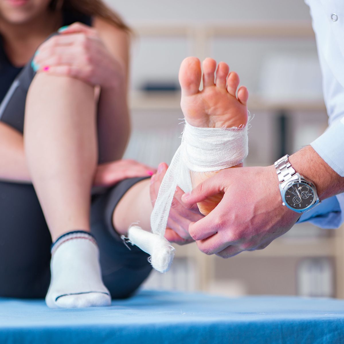 A woman is getting her foot bandaged by a doctor.