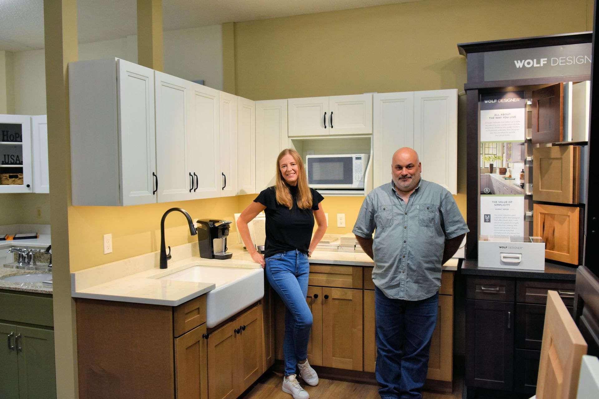 A man and a woman are standing in a kitchen.