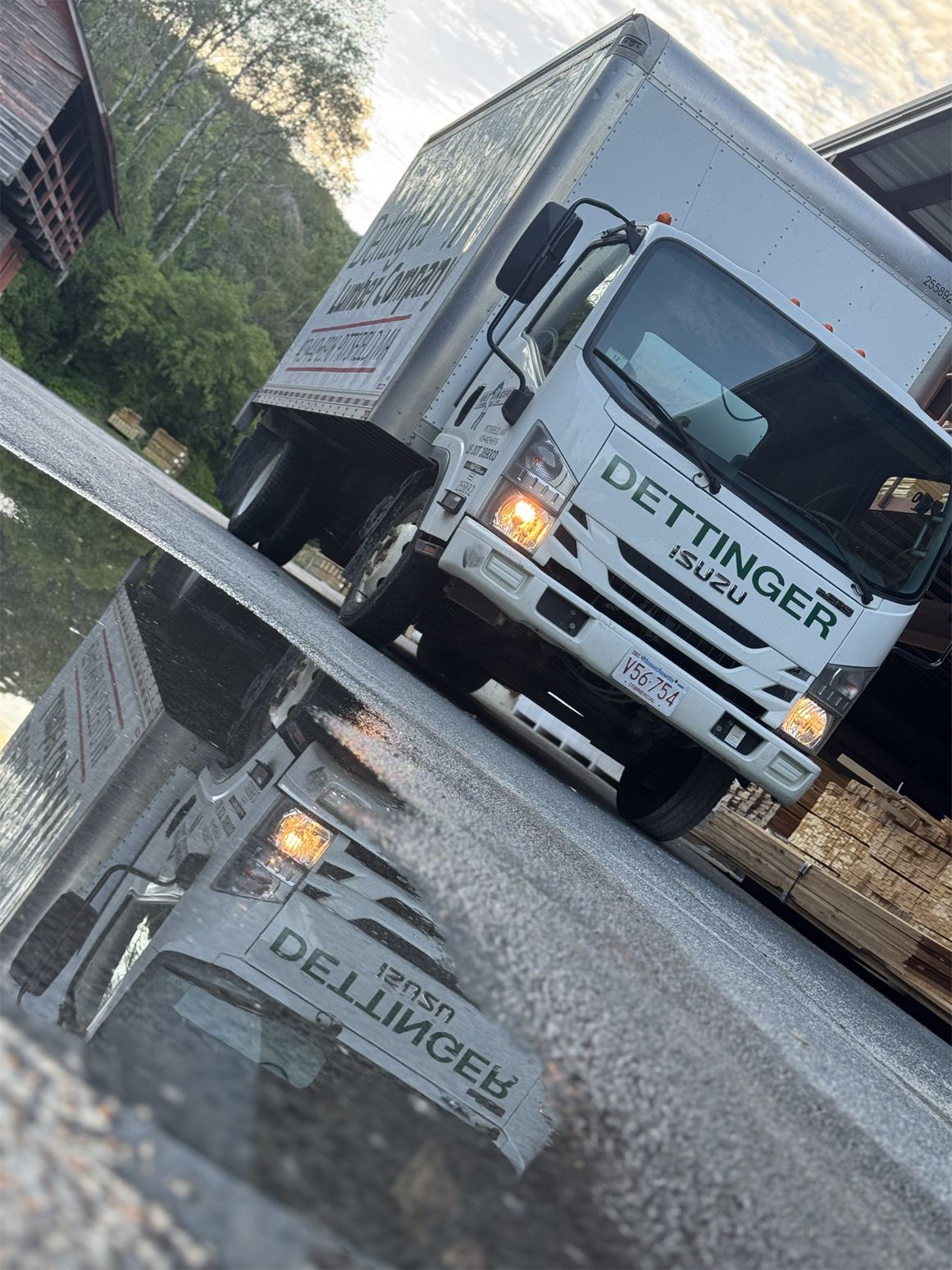 A white truck is parked on a wet street.