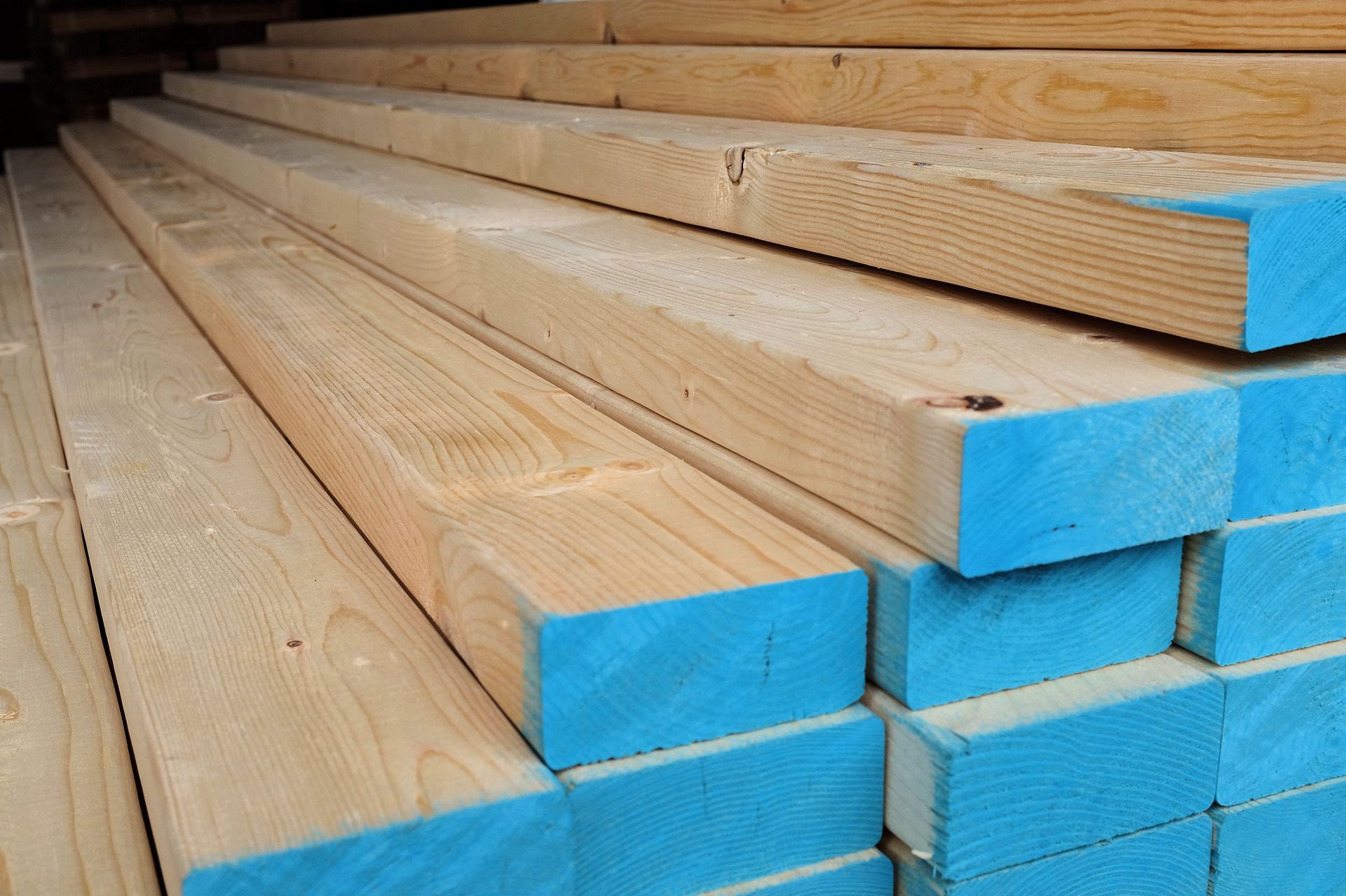 A stack of wooden boards with blue edges are stacked on top of each other.