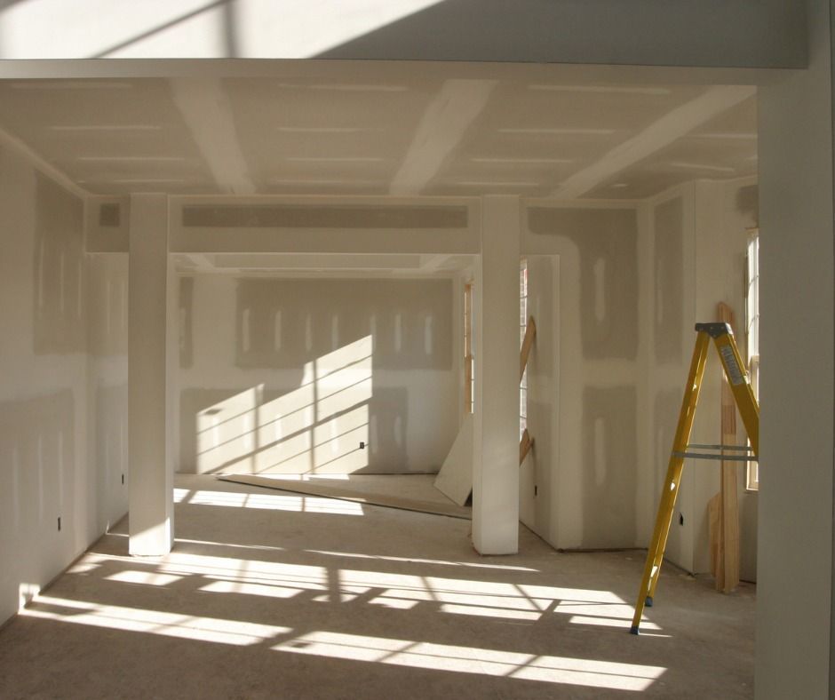 An empty room with a yellow ladder in the middle.