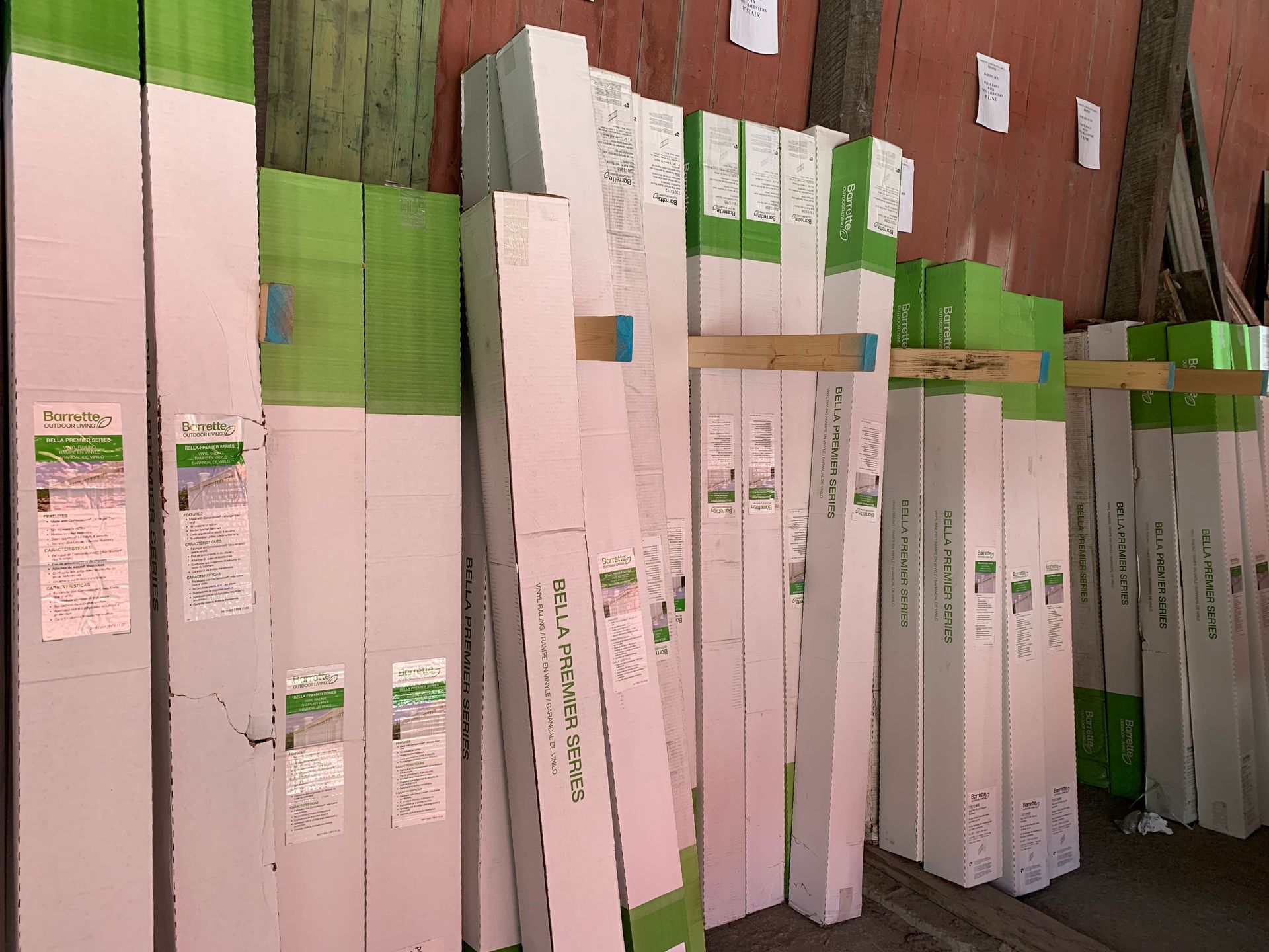 Stacks of white door trim with green and white labels and packaging in a warehouse setting.