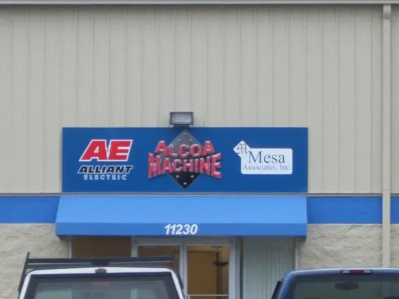Sign for Alcoa Machine, Alliant Electric, Mesa Associates; blue background, awning, building with address 11230.