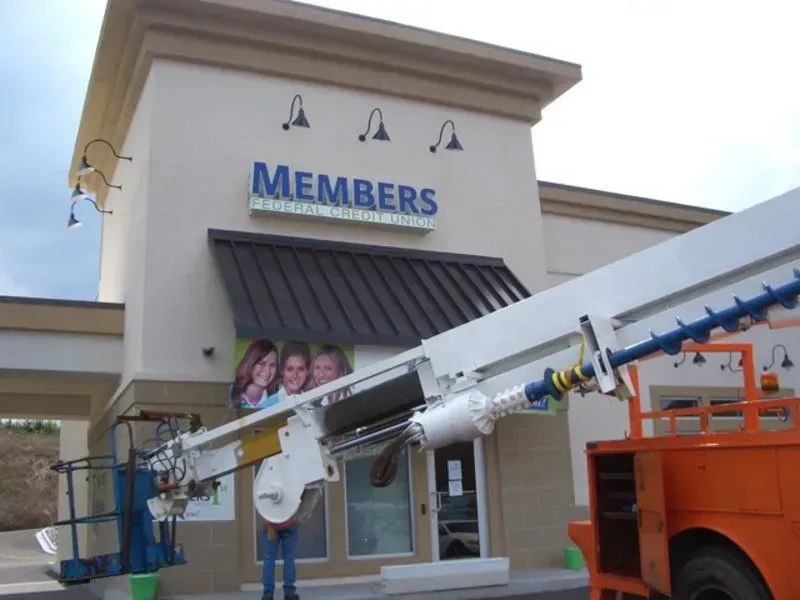 A lift truck installing a sign that says 