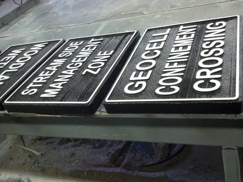 Three black and white engraved signs: 