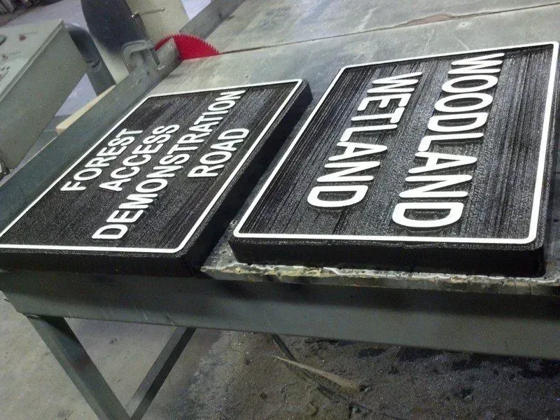 Two rectangular black and white road signs: 