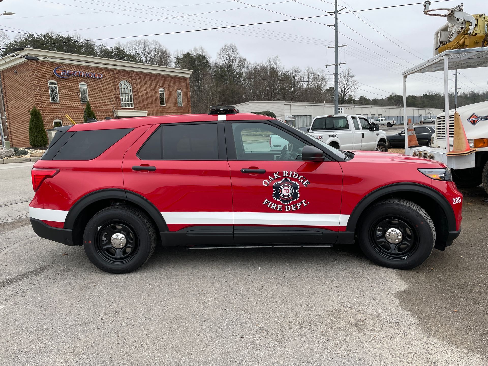 Red and white fire department SUV parked on a paved lot; logo on the side.