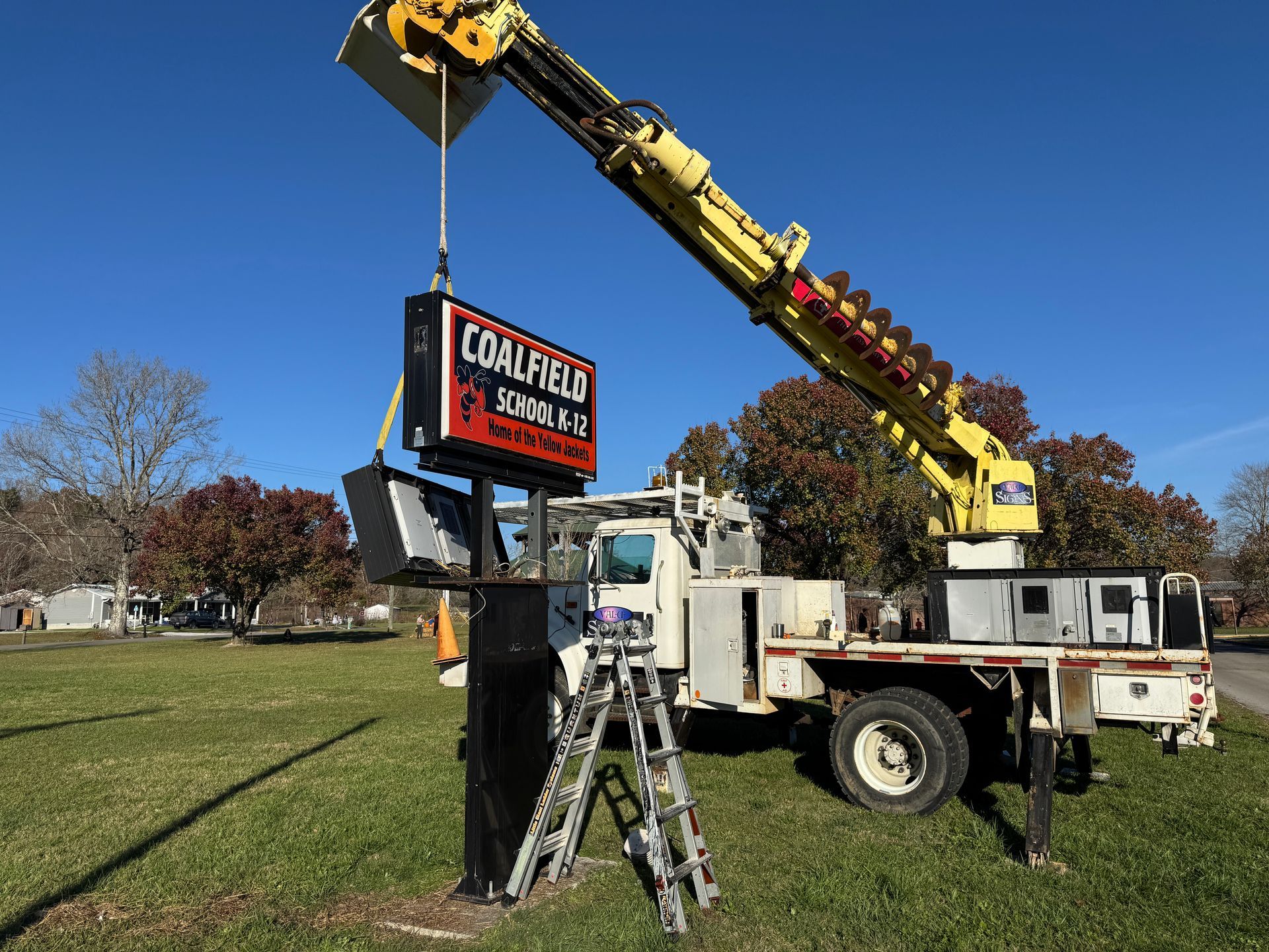 A crane installing a sign that reads 