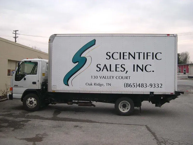 White box truck with Scientific Sales, Inc. logo parked outside a building.