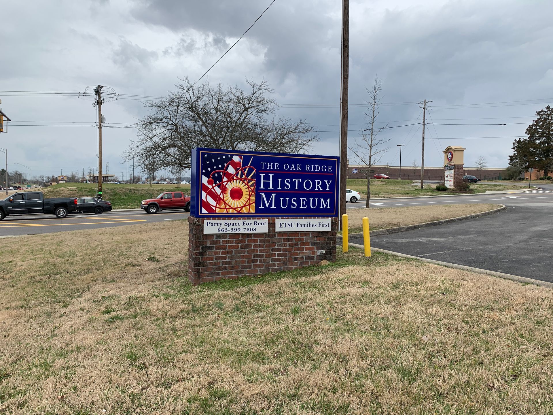 Sign for The Vermilion Parish History Museum with US flag on a cloudy day.