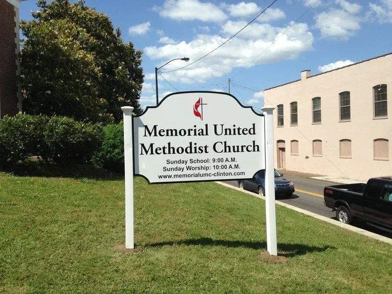 Sign for Memorial United Methodist Church; white with black text, red cross symbol.
