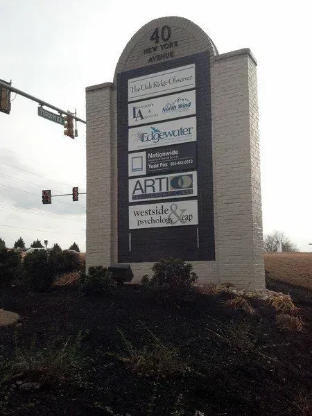 Signpost for a business center at 40 New York Avenue with tenant logos.