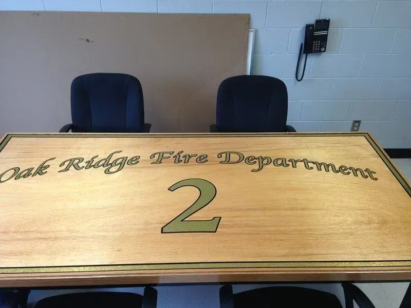 Desk for Oak Ridge Fire Department 2, with gold lettering and two office chairs behind it.