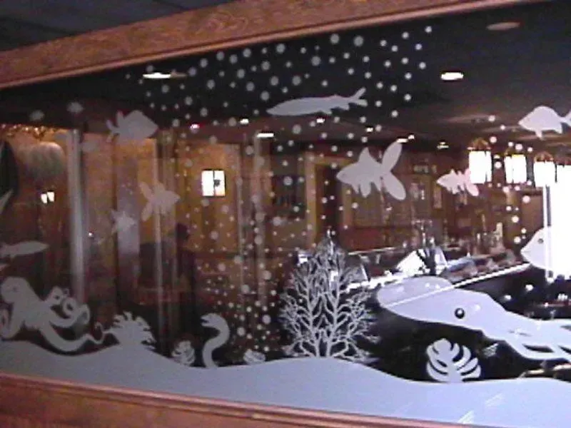 Etched glass window with underwater scene featuring fish, octopus, and coral.