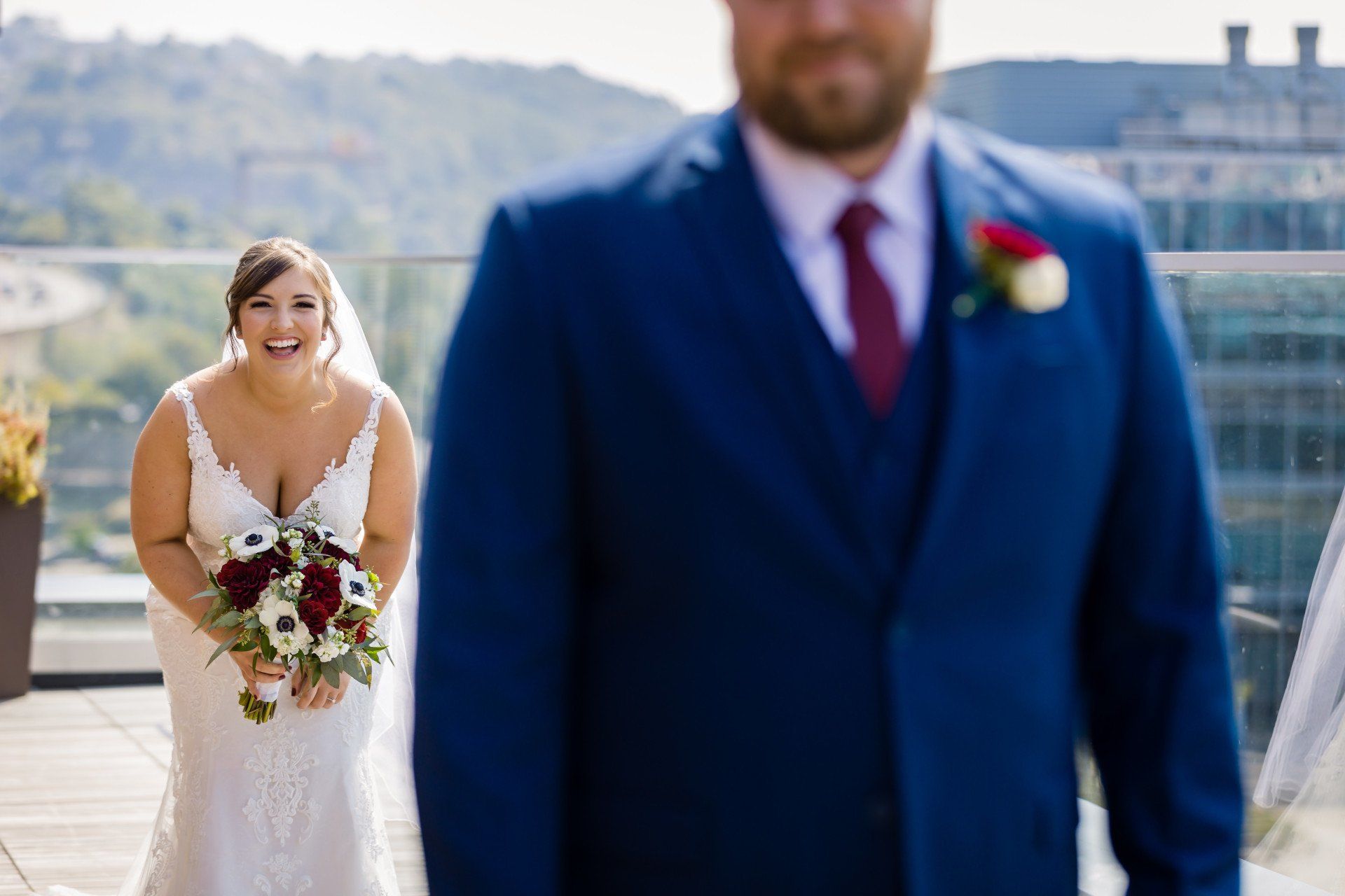 A bride and groom are standing next to each other on a balcony.